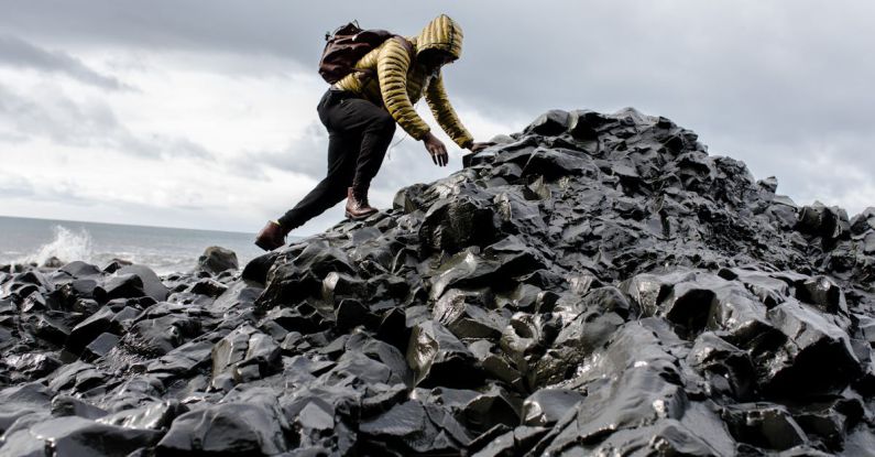 Challenges - Man Wearing Hoodie and Black Pants Climbing Up Pile of Rocks